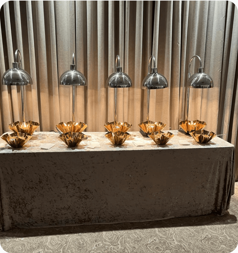 A buffet line with copper serving bowls under heat lamps