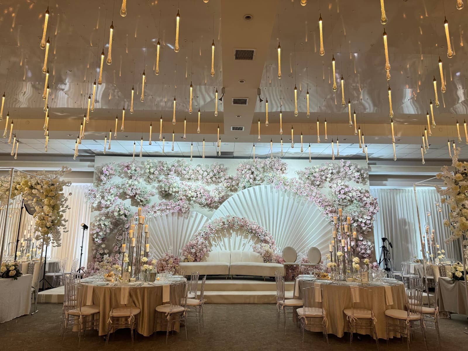 Ballroom with a fan-shaped floral backdrop and set tables