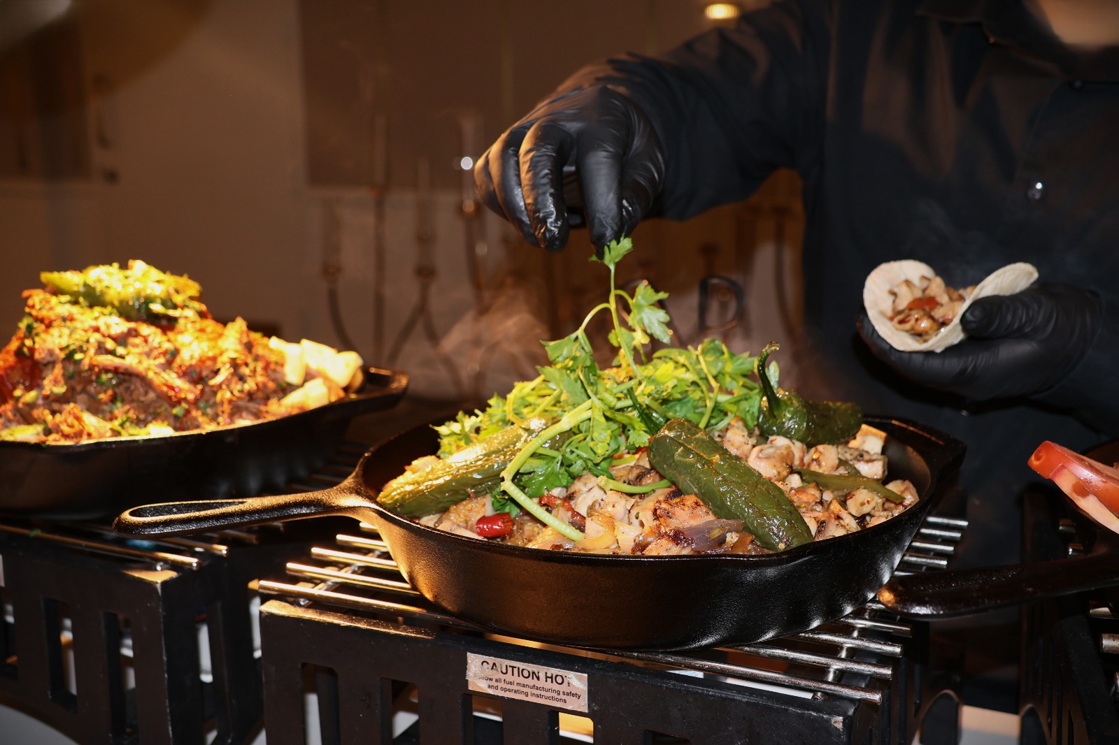 A chef finishing a dish at a live food station