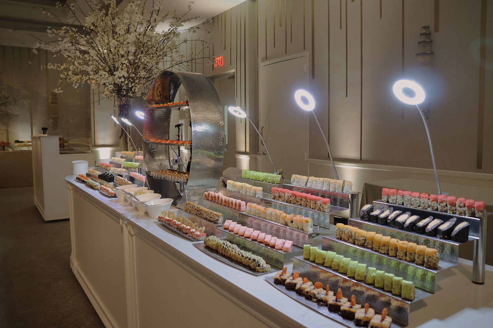 A long dessert display with rows of pastries