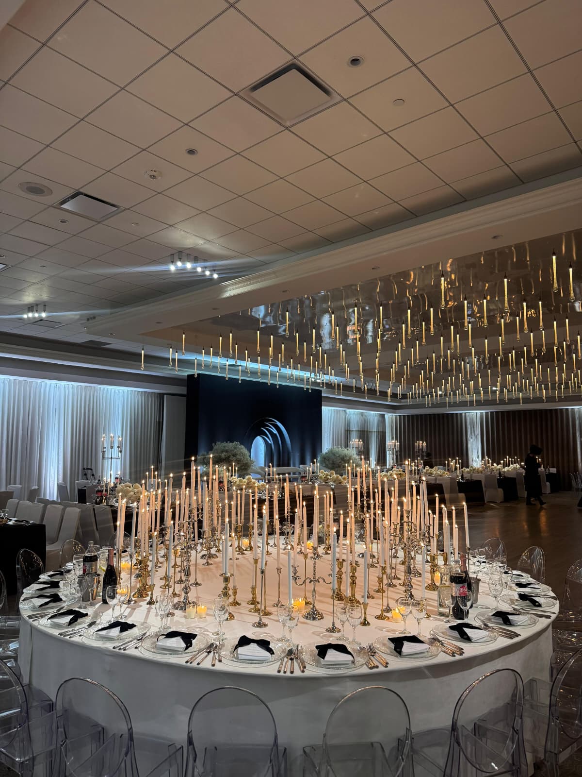 A round table crowned with dozens of tapered candles