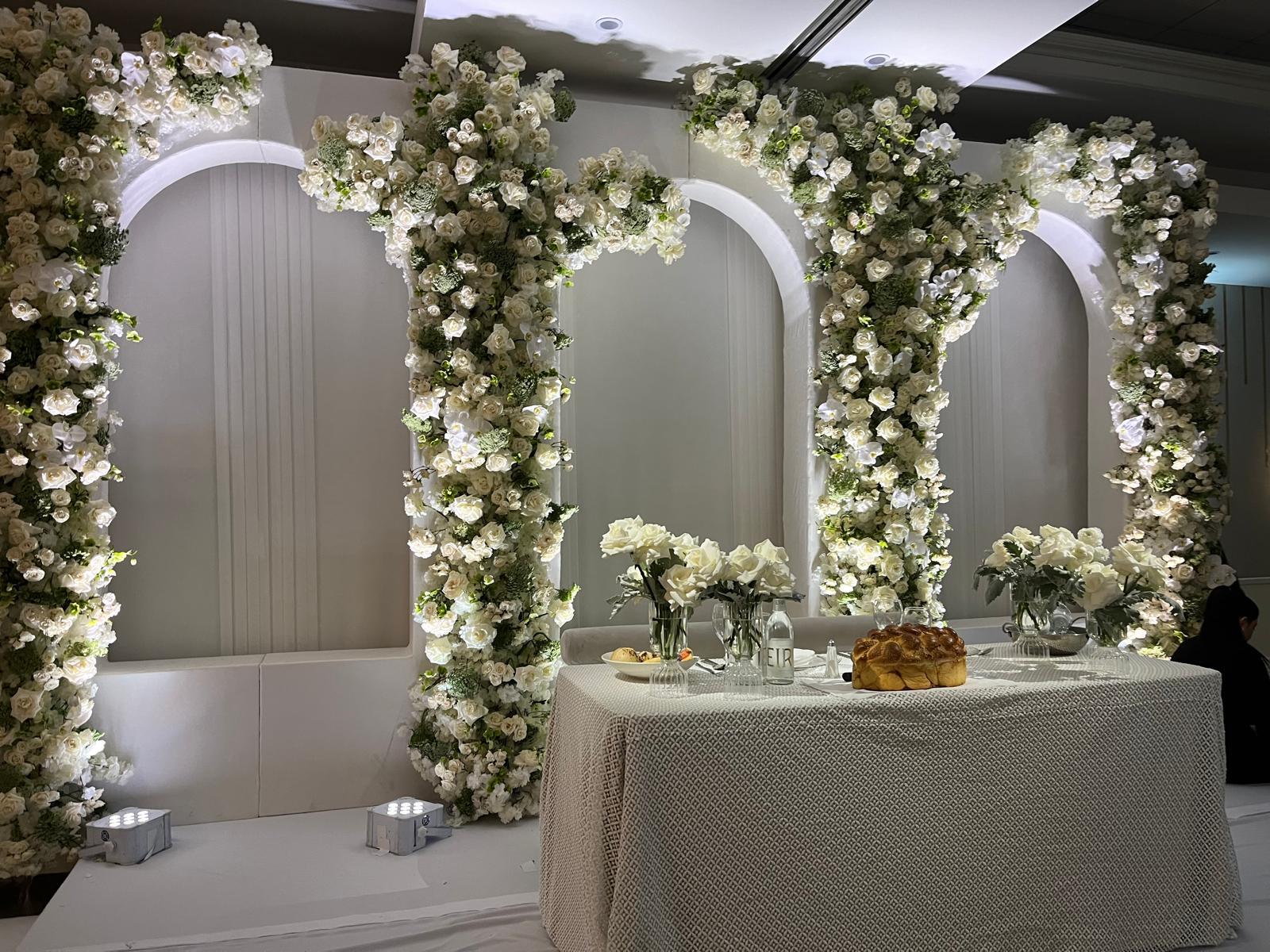 Floral arches framing a table in the ballroom